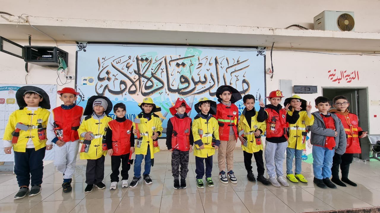 طلاب مدارس قادة الأمة أمام جدارية المدرسة